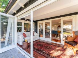 A sunroom with a sofa and coffee table at Waterside Bliss - Taupo Holiday Home, Taupo Central