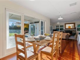 A dining room with a table, chairs, and a fireplace at Waterside Bliss - Taupo Holiday Home Taupo Central