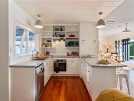 A kitchen with appliances and table at Waterside Bliss - Taupo Holiday Home Taupo Central