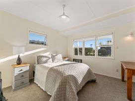 A bedroom with a bed and windows at Waterside Bliss - Taupo Holiday Home Taupo Central