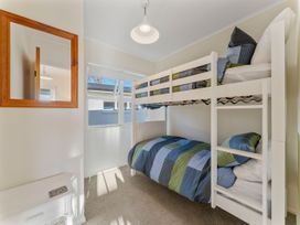 A bedroom with a bunk bed and a single bed at Waterside Bliss - Taupo Holiday Home in Taupo Central