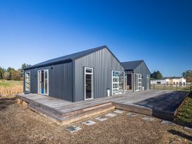 Exterior view of a dark gray metal house with multiple windows and doors on a wooden deck at Mountain Haus - Ohakune Holiday Home in Ohakune