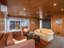 A living room with two sofas an armchair and a coffee table on a patterned rug at Mountain Haus Ohakune