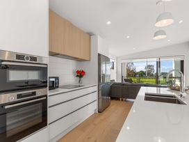A kitchen with appliances and a window view at Tauranga Holiday Home in Tauranga