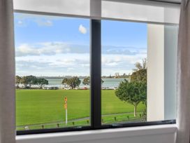 A view from a window overlooking grass and water at Tauranga Holiday Home in Tauranga