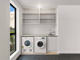 A laundry room with washing and drying machines at Tauranga Holiday Home in Tauranga