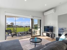 A living room with a television and sliding door at Tauranga Holiday Home in Tauranga