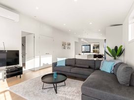 A living room with a sofa and television at Tauranga Holiday Home in Tauranga