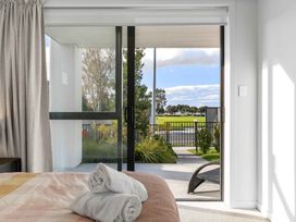 A bedroom with a glass door leading to a garden at Tauranga Holiday Home in Tauranga