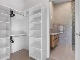 A bathroom with a closet and shower at Tauranga Holiday Home in Tauranga