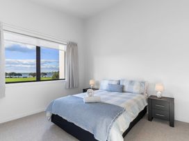 A bedroom with a bed and view of the outside at Tauranga Holiday Home, Tauranga