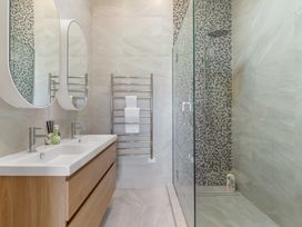 A bathroom with double sinks and a shower at Tauranga Holiday Home in Tauranga