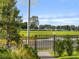 A view of a park with grass and trees from a gated outdoor area at Tauranga Holiday Home in Tauranga