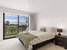 A bedroom with a bed and bedside table at Tauranga Holiday Home in Tauranga