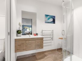 A bathroom with a shower and sink at Island Views - Waihi Beach Holiday Home Waihi Beach