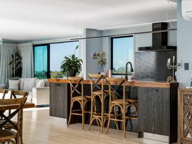 A kitchen with a countertop and stools at Island Views - Waihi Beach Holiday Home Waihi Beach