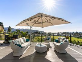An outdoor patio with seating and table at Island Views - Waihi Beach Holiday Home, Waihi Beach