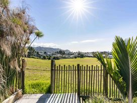 An outdoor view with a fence and grass at Island Views - Waihi Beach Holiday Home, Waihi Beach