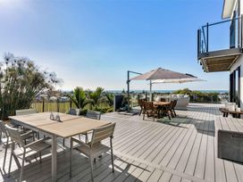 A patio area with dining table and chairs at Island Views - Waihi Beach