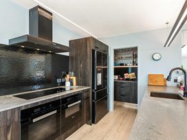 A kitchen with appliances and cabinets at Island Views - Waihi Beach Holiday Home, Waihi Beach