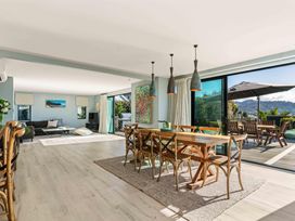 A dining room with a table and chairs by the sliding doors at Island Views - Waihi Beach Holiday Home, Waihi Beach