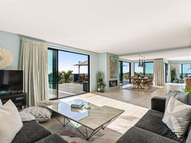A living room with a sofa and dining area at Island Views - Waihi Beach Holiday Home, Waihi Beach