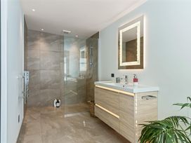 A bathroom with a shower and sink at Island Views - Waihi Beach Holiday Home in Waihi Beach