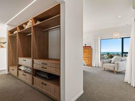 A bedroom with a wardrobe and couch at Island Views - Waihi Beach Holiday Home Waihi Beach