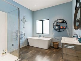 A bathroom with a bathtub, shower, and sink at Island Views - Waihi Beach Holiday Home, Waihi Beach
