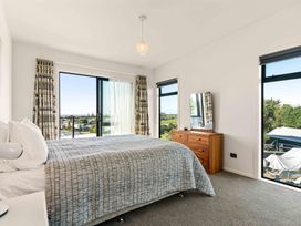 A bedroom with a bed and a dresser at Island Views - Waihi Beach Holiday Home Waihi Beach