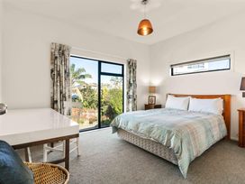 A bedroom with a bed and desk at Island Views - Waihi Beach Holiday Home Waihi Beach