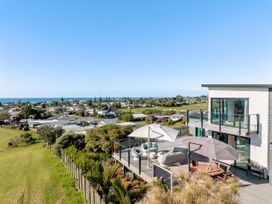 A house with a deck overlooking the ocean at Island Views - Waihi Beach Holiday Home, Waihi Beach
