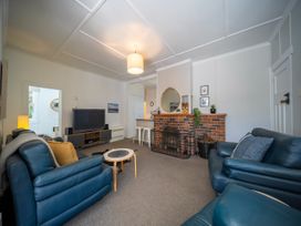 A living room with a television and fireplace at Fiordland Hideaway - Te Anau