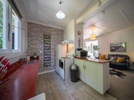 A kitchen with appliances and seating at Fiordland Hideaway - Te Anau