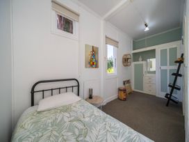 A bedroom with a bed and cabinet at Fiordland Hideaway - Te Anau