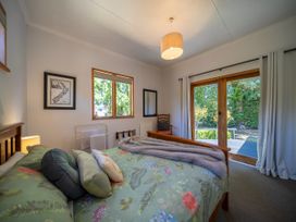 A bedroom with a bed and sliding door at Fiordland Hideaway - Te Anau