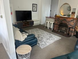 A living room with a sofa, tv, and fireplace at Fiordland Hideaway - Te Anau