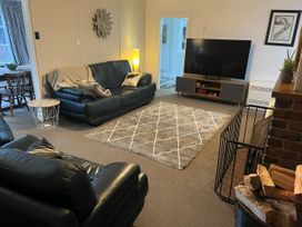 A living room with a sofa and television at Fiordland Hideaway - Te Anau