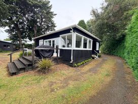 A house with a deck and grill in the outdoor area at Fiordland Hideaway - Te Anau