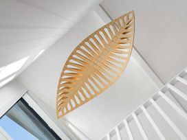 A wooden light fixture hanging from the ceiling at Waihi Beach Holiday Home in Waihi Beach