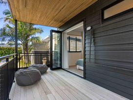 A balcony with bean bags and a view of palm trees at Waihi Beach Holiday Home in Waihi Beach