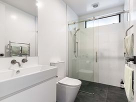 A bathroom with a sink, toilet, and shower at Waihi Beach Holiday Home in Waihi Beach