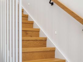 Stairs with wooden steps and railing at Waihi Beach Holiday Home in Waihi Beach
