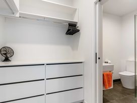 A bathroom with a closet and a toilet in Waihi Beach Holiday Home Waihi Beach