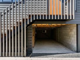 A garage with stairs and railing at Waihi Beach Holiday Home in Waihi Beach