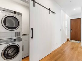 A laundry room with a washing machine and dryer at Waihi Beach Holiday Home in Waihi Beach