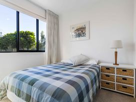A bedroom with a bed and nightstand at Waihi Beach Holiday Home in Waihi Beach