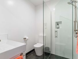 A bathroom with a shower and toilet at Waihi Beach Holiday Home in Waihi Beach