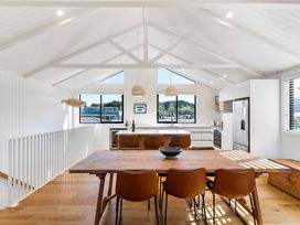 A dining room with a table and chairs at Waihi Beach Holiday Home in Waihi Beach