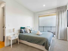 A bedroom with a bed and bedside table at Waihi Beach Holiday Home Waihi Beach